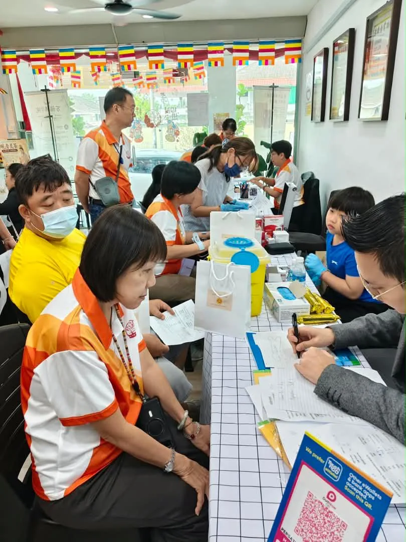义工在健检活动中为民众登记与量测,现场设有检验站